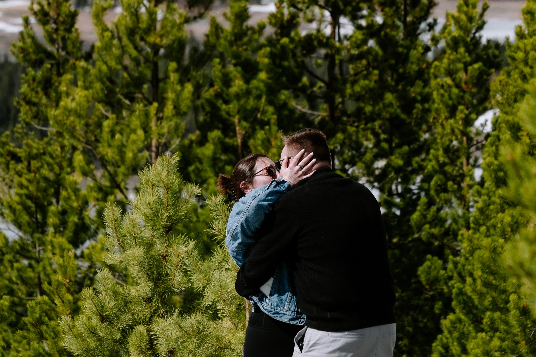 Newly engaged couple embracing with mountain views